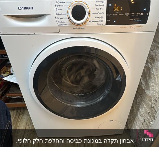 מכונת כביסה פועלת על רצפת עץ